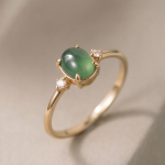 Oval Jade Cabochon Ring with Graduated Cubic Zirconia Shoulders in Gold Tone
