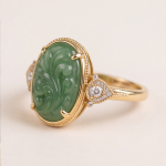 Oval Carved Green Jade Ring with Trillion Cubic Zirconia Shoulders in Gold Tone